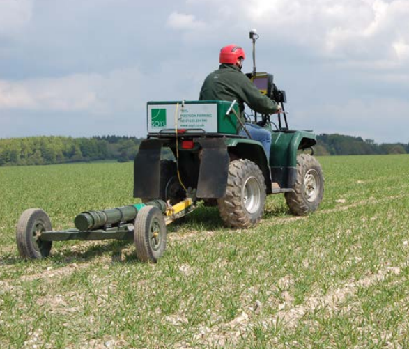 Farmer driving Soil electromagnetic inductance (EMI) scanner through field of crops